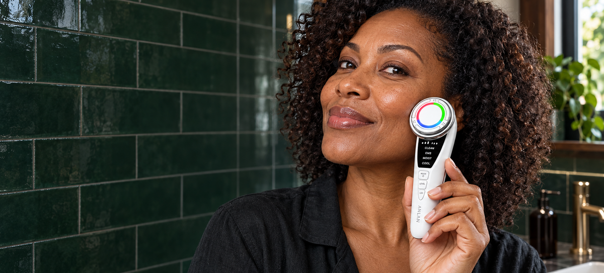Woman using ANLAN facial device in a green tiled bathroom